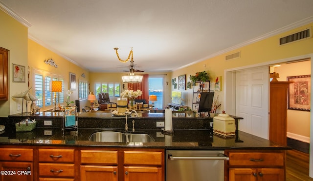 kitchen featuring dark stone countertops, ornamental molding, sink, and a chandelier