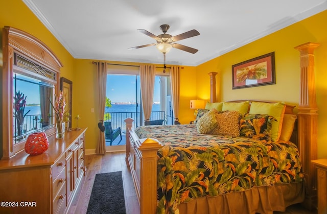 bedroom featuring access to exterior, light hardwood / wood-style floors, a water view, and multiple windows