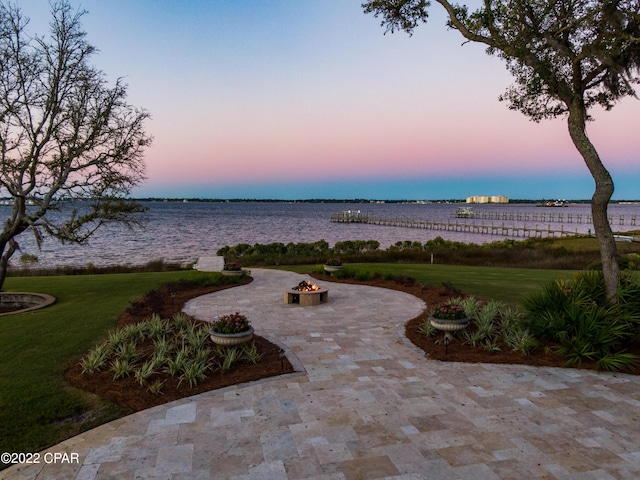 3730 Preserve Bay Blvd, Panama City, FL 32408 - patio terrace at dusk with a yard, a water view, and an outdoor fire pit