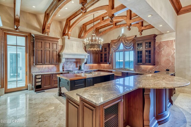 3730 Preserve Bay Blvd, Panama City, FL 32408 - kitchen featuring a large island, a water view, decorative backsplash, and light stone counters