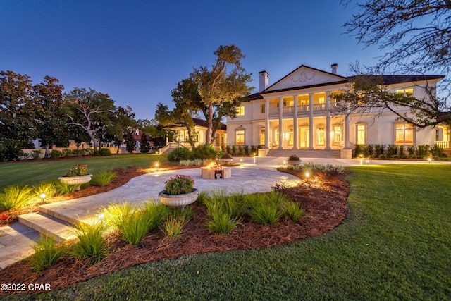 3730 Preserve Bay Blvd, Panama City, FL 32408 - back house at dusk featuring a balcony, a yard, and an outdoor fire pit