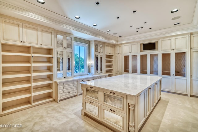 3730 Preserve Bay Blvd, Panama City, FL 32408 - kitchen with cream cabinetry, a kitchen island, light stone countertops, and ornamental molding