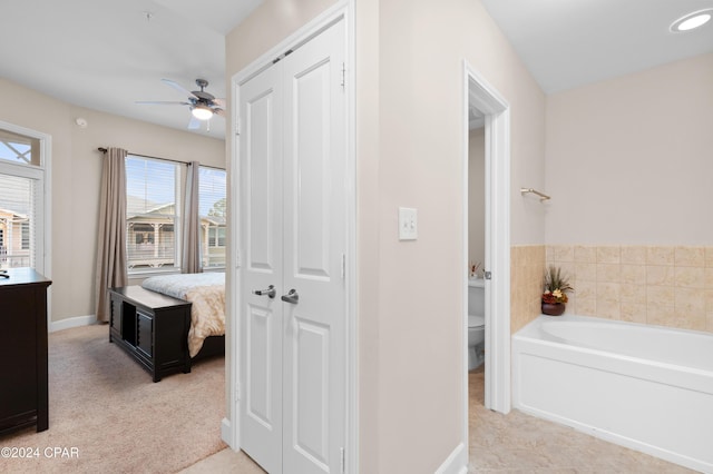 interior space featuring a washtub, ceiling fan, and toilet