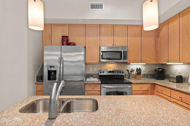 kitchen featuring decorative backsplash, sink, light stone countertops, and stainless steel appliances