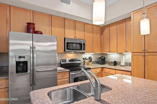 kitchen with backsplash, light stone countertops, sink, and appliances with stainless steel finishes