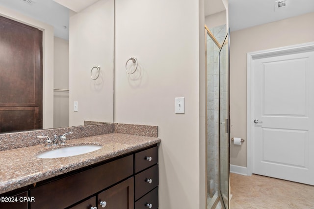 bathroom with tile patterned flooring, vanity, and a shower with shower door