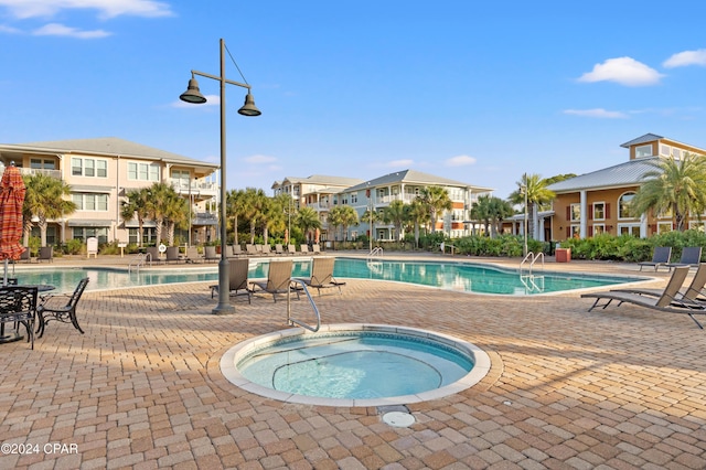 view of pool featuring a hot tub and a patio area