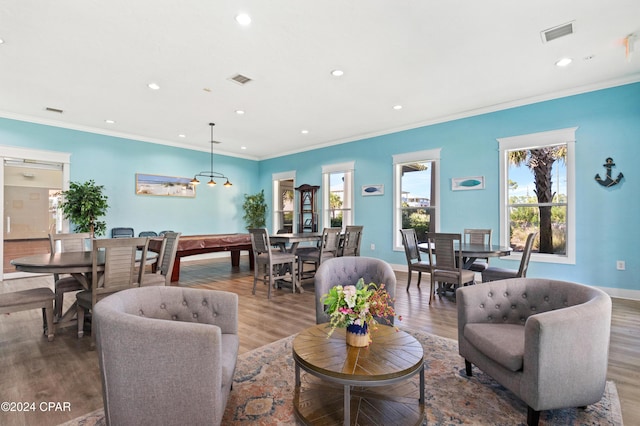 living room with pool table, ornamental molding, a healthy amount of sunlight, and wood-type flooring