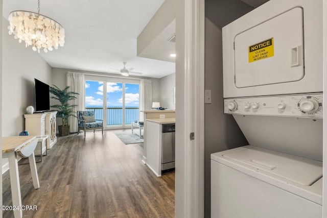 washroom with ceiling fan with notable chandelier, dark hardwood / wood-style flooring, and stacked washer and dryer