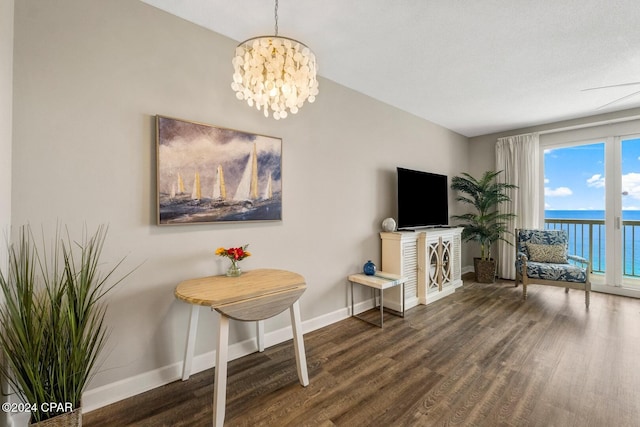 living area with dark hardwood / wood-style floors and an inviting chandelier