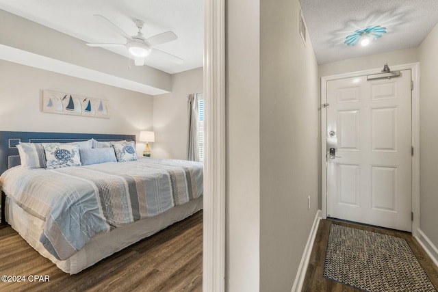 bedroom featuring a textured ceiling, ceiling fan, and dark wood-type flooring