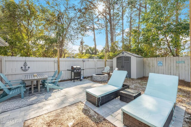 view of patio / terrace featuring area for grilling, a fire pit, and a storage shed