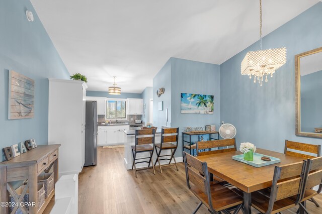 dining area featuring light hardwood / wood-style floors, sink, and an inviting chandelier