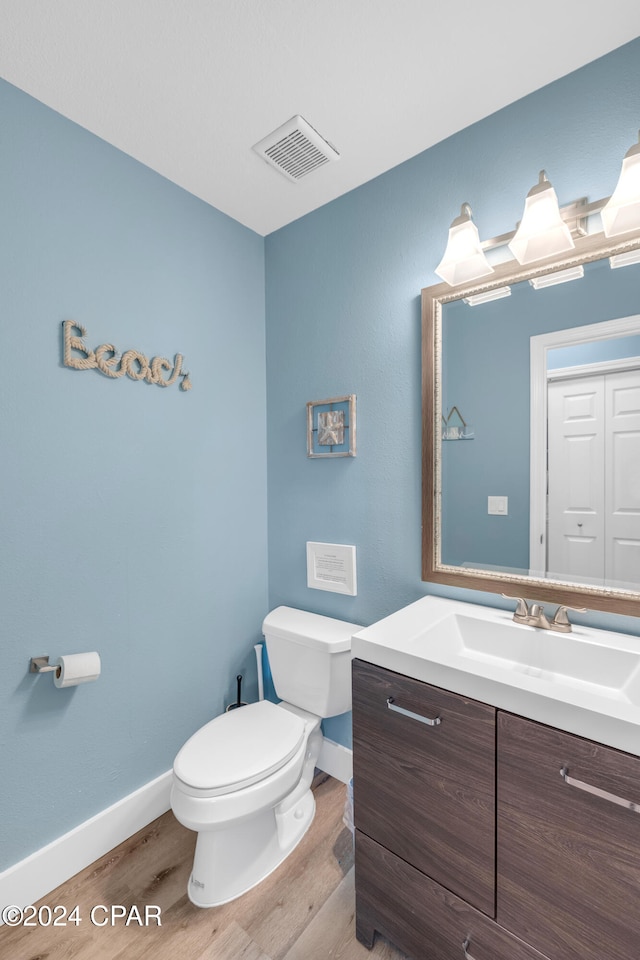 bathroom with hardwood / wood-style flooring, vanity, and toilet