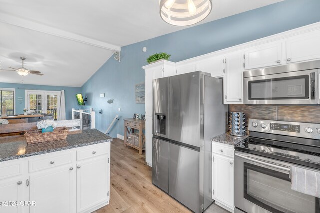 kitchen featuring vaulted ceiling with beams, white cabinetry, stainless steel appliances, and light wood-type flooring