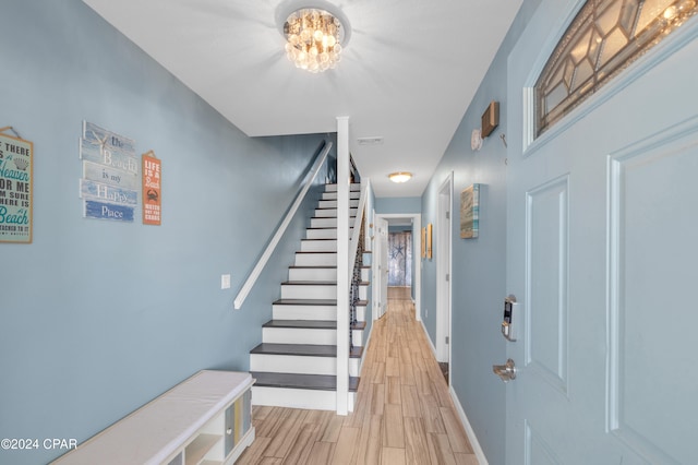 entrance foyer featuring light hardwood / wood-style floors and a notable chandelier