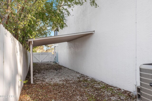 view of home's exterior with a carport and central AC unit