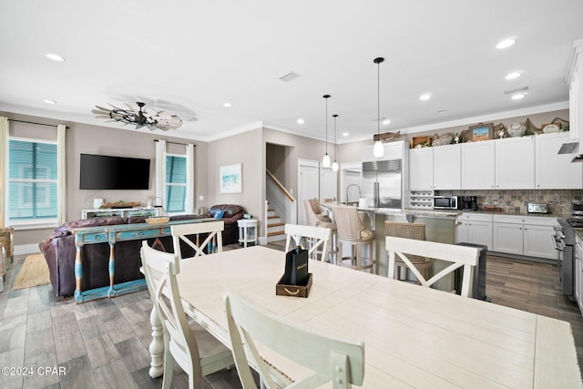 dining area with dark hardwood / wood-style flooring, plenty of natural light, ceiling fan, and ornamental molding