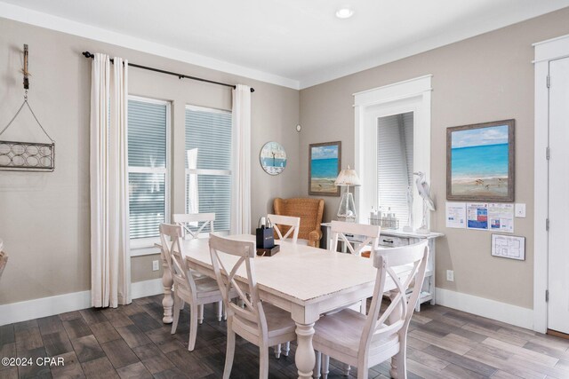 dining space featuring hardwood / wood-style flooring, a wealth of natural light, and ornamental molding