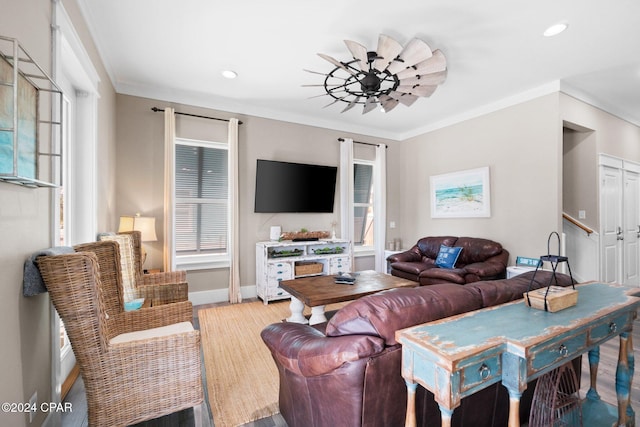 living room featuring light hardwood / wood-style flooring, a healthy amount of sunlight, and ornamental molding