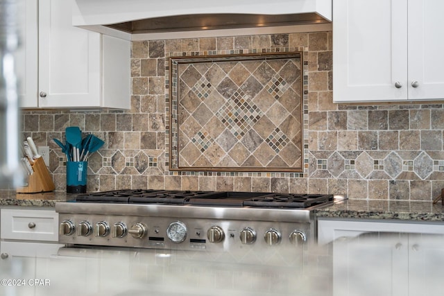 kitchen with white cabinets, stone countertops, and tasteful backsplash