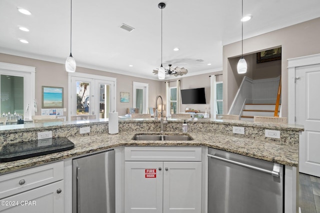 kitchen with white cabinets, hanging light fixtures, sink, and appliances with stainless steel finishes