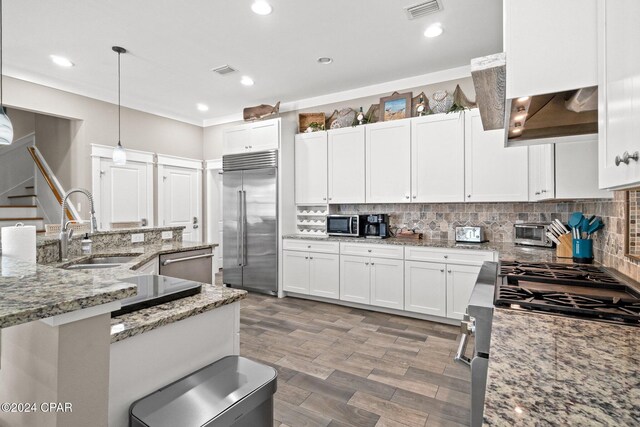 kitchen with pendant lighting, white cabinetry, sink, and appliances with stainless steel finishes