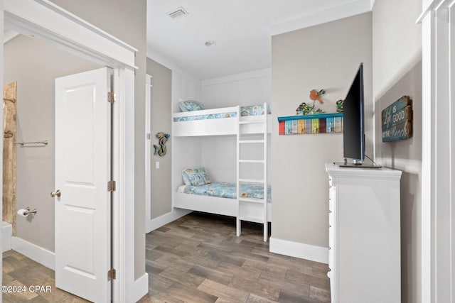 bedroom with hardwood / wood-style floors and ornamental molding