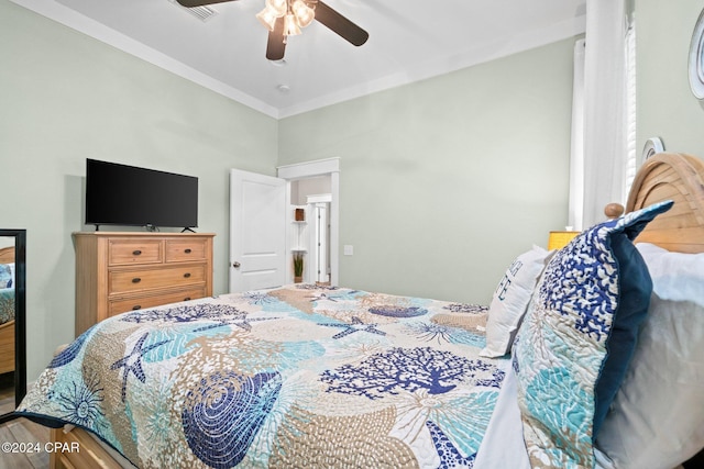 bedroom with hardwood / wood-style floors, ceiling fan, and crown molding