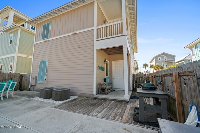 rear view of house featuring a patio, a balcony, a deck, and cooling unit