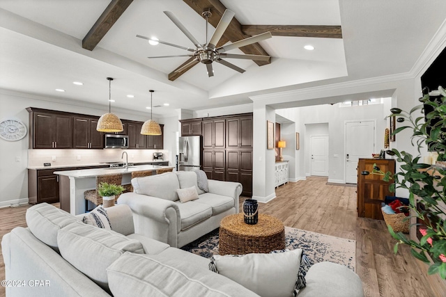 living room featuring lofted ceiling with beams, sink, light hardwood / wood-style flooring, ceiling fan, and ornamental molding