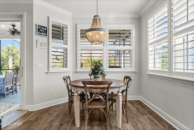 dining space with crown molding, ceiling fan with notable chandelier, and dark hardwood / wood-style floors