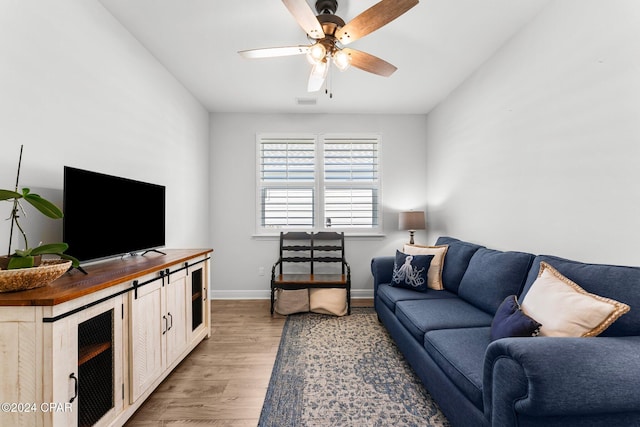 living room with light hardwood / wood-style floors and ceiling fan