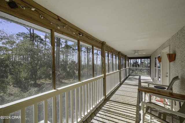 unfurnished sunroom with ceiling fan