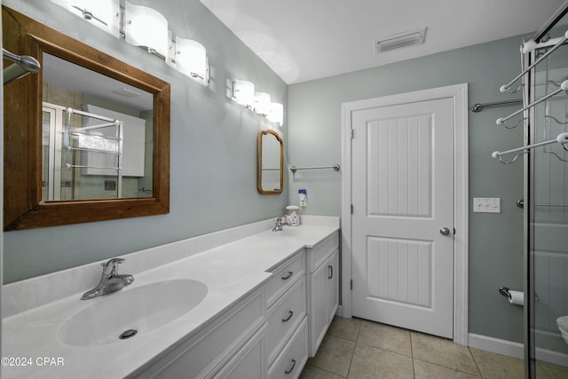 bathroom with tile patterned flooring, vanity, and a shower with shower door