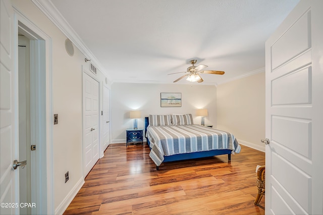 bedroom with light wood-type flooring, baseboards, ornamental molding, and a ceiling fan