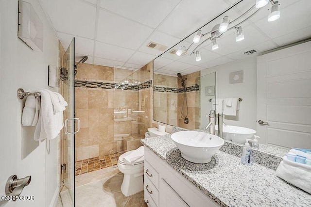 bathroom with visible vents, toilet, a shower stall, and vanity