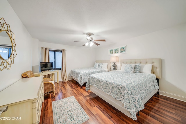 bedroom with ceiling fan, wood finished floors, and baseboards