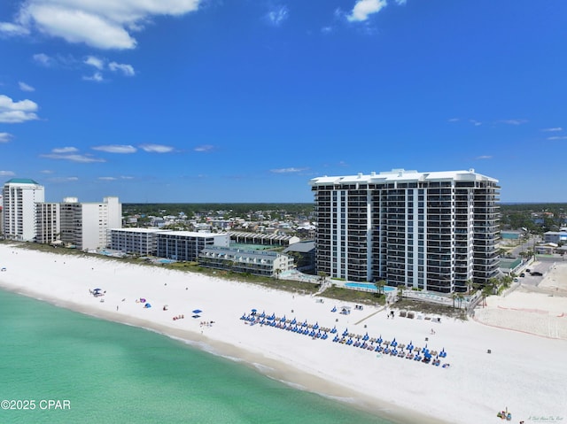 drone / aerial view with a water view, a view of the beach, and a city view