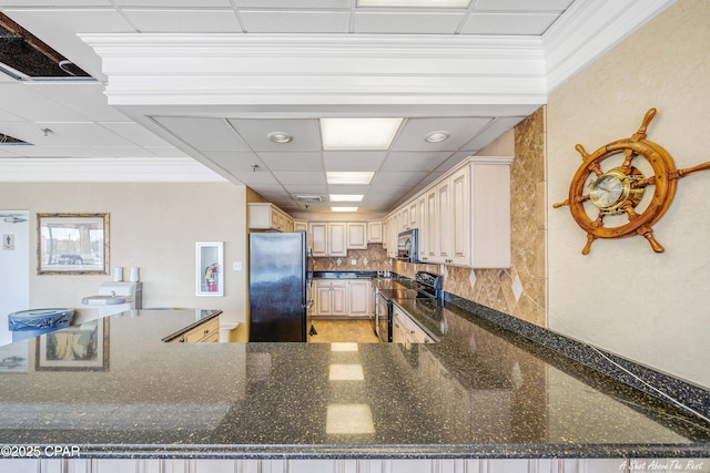 kitchen featuring decorative backsplash, dark stone countertops, crown molding, a paneled ceiling, and black appliances