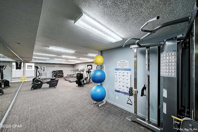 exercise room with a textured ceiling and baseboards