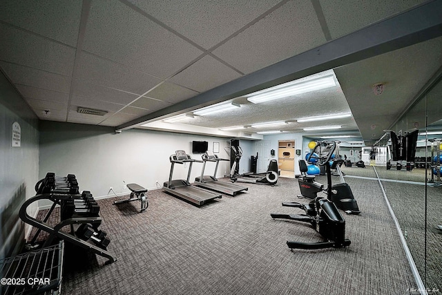 gym featuring baseboards, visible vents, and a drop ceiling