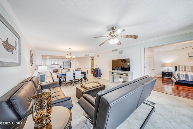 living room featuring crown molding, visible vents, a textured ceiling, baseboards, and ceiling fan with notable chandelier