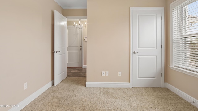 unfurnished bedroom with light carpet, a chandelier, and ornamental molding