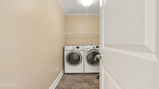 laundry room featuring dark wood-type flooring, washer and dryer, and ornamental molding