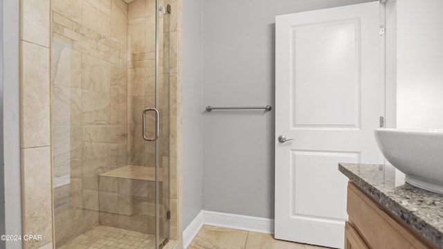 bathroom featuring tile patterned flooring, vanity, and a shower with shower door