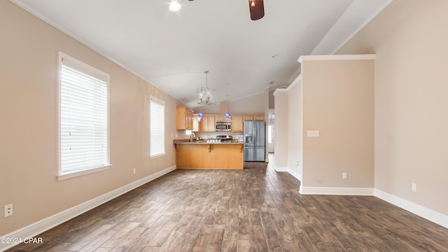 unfurnished living room with lofted ceiling, ceiling fan with notable chandelier, dark hardwood / wood-style floors, and ornamental molding