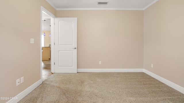 carpeted spare room featuring crown molding