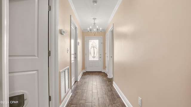 doorway to outside with hardwood / wood-style floors, crown molding, and a chandelier