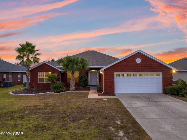 ranch-style house with a garage, cooling unit, and a lawn